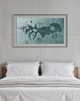 A framed abstract wall art print with a teal and black paint splatter design hangs above a neatly made bed in a modern, minimalist bedroom with concrete walls and large windows showing a mountain view.