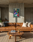 Modern living room with brown leather sofa, wooden coffee table, and colorful abstract painting on concrete wall.
