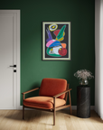 Modern interior with a colorful abstract painting on a green wall, an orange armchair, and a black side table with flowers.