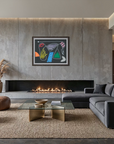 A modern living room featuring a large concrete fireplace wall with a colorful framed abstract artwork, a dark gray sectional sofa, brown leather poufs, and a glass-top coffee table on a woven rug.