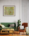 Bright living room setting with green sofa, light wood cocktail table, leather side chair with blanket featuring an abstract art piece against the white wall