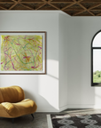 Sunny sitting area with a plush light orange chair, arched windows, a black and white rug and an abstract piece of artwork on the wall