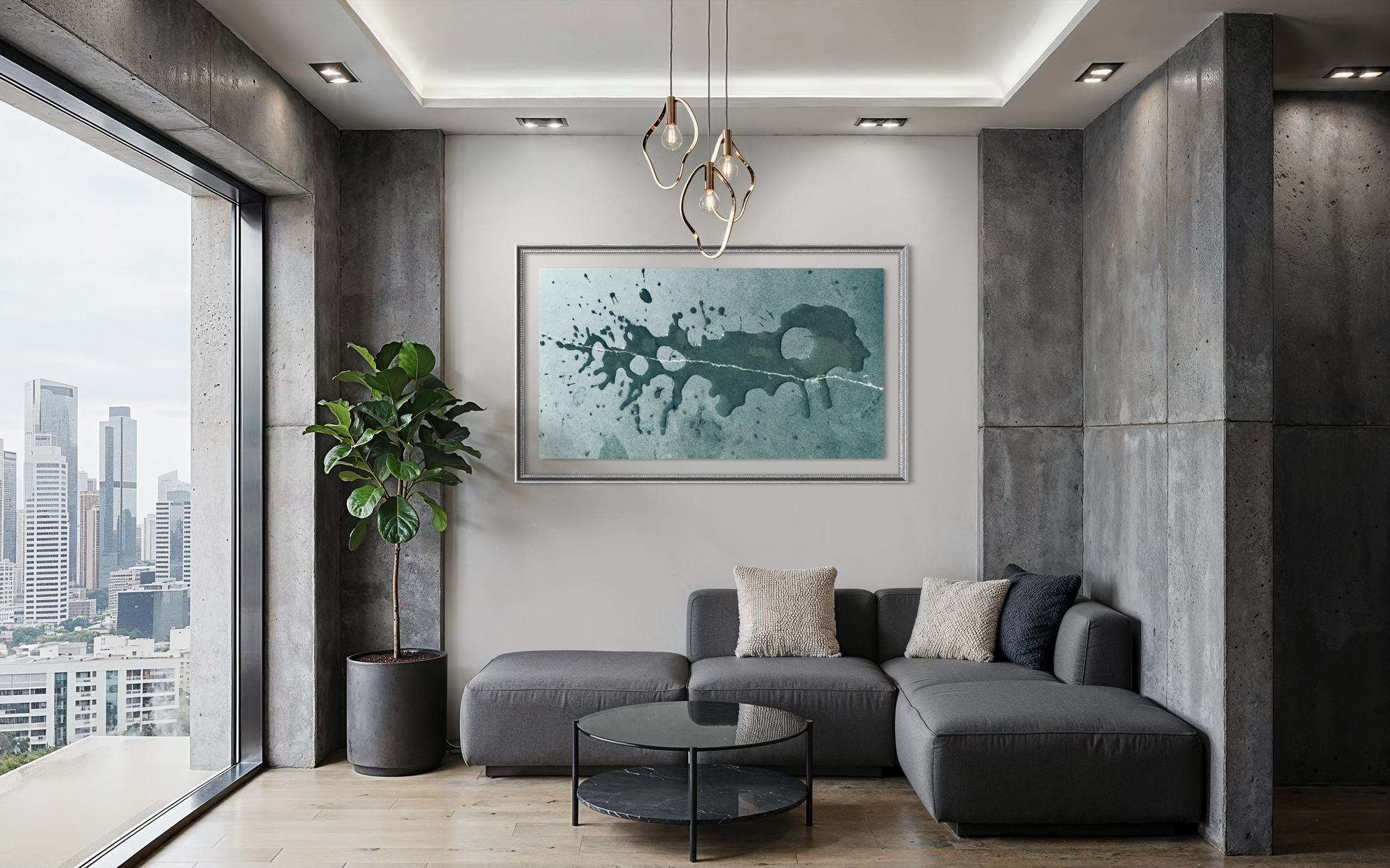 A modern living room with a gray sectional sofa, a round glass coffee table, a potted plant, and a large framed abstract art print on the wall above the sofa.