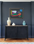 Living room with a dark blue wall, black sideboard, and colorful abstract painting.