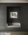 A framed abstract wall art print with gray, white, and lime green brushstrokes, displayed in a recessed niche above a modern gray upholstered bench against a dark wood-paneled wall.