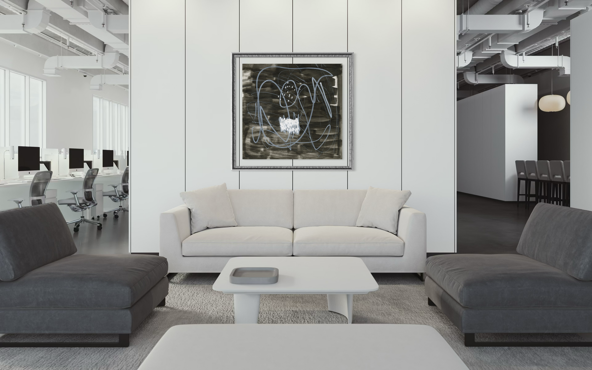 A modern living room setup featuring a white three-seater sofa centered against a white paneled wall with a framed abstract black and white print. Flanking the sofa are two dark gray armchairs, with a low white rectangular coffee table in front.