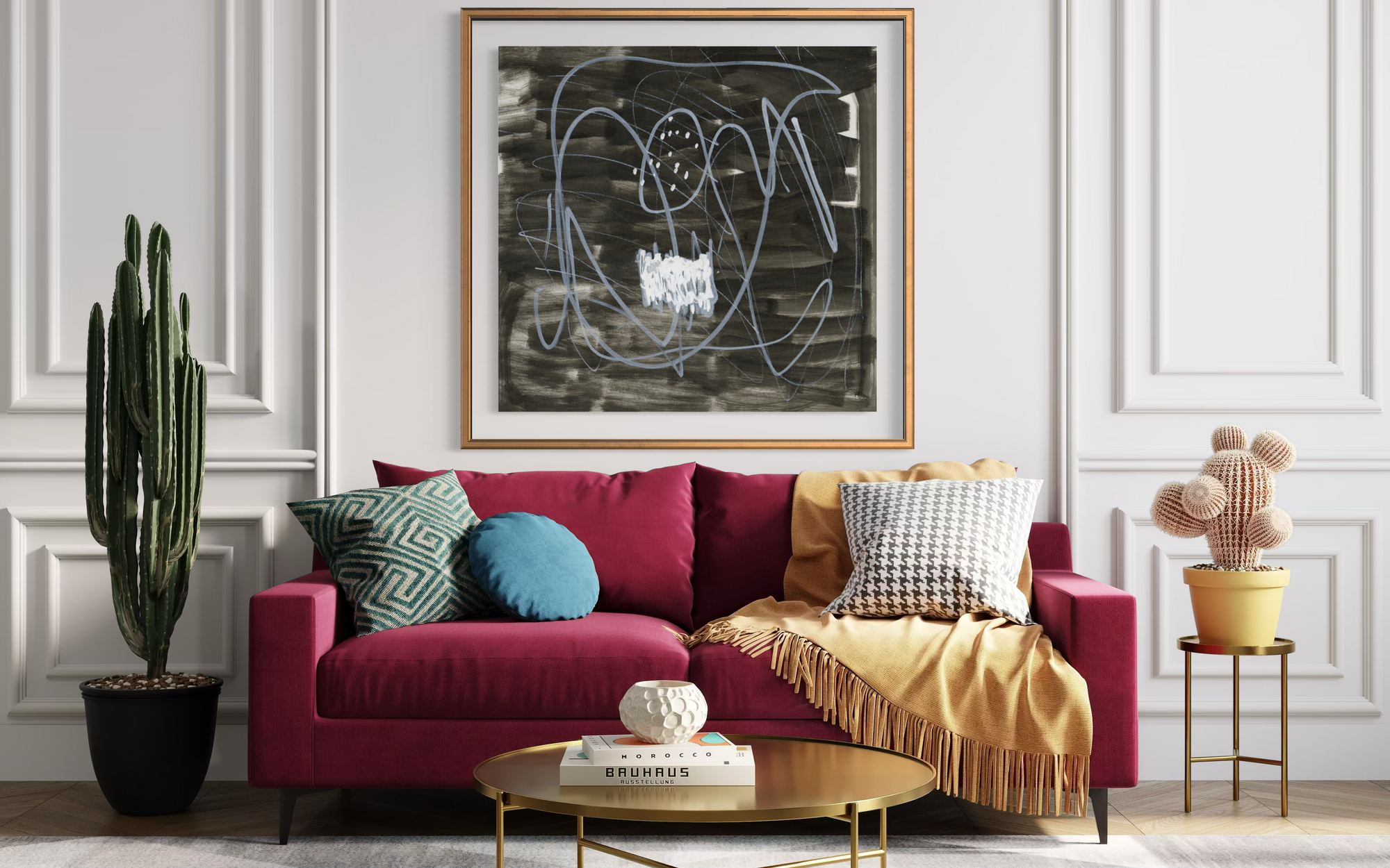 A framed abstract black and white painting hangs on a white paneled wall above a magenta sofa styled with accent pillows and a yellow throw blanket in a bright living room.