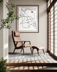 Brown leather chair with foot rest facing a sunny paneled sliding door with abstract artwork on wall