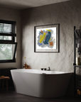Bathroom setting with large white tub, concrete gray walls with an open window on the side and a colorful abstract painting above the tub