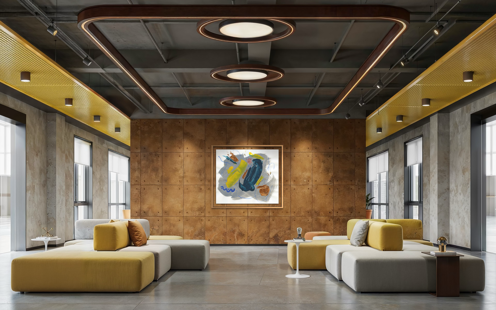 Expansive lobby with grey and yellow seating with a copper colored will displaying colorful abstract artwork