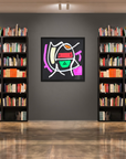 A framed abstract geometric art print hangs on a dark gray wall in a modern library or study, flanked by tall black bookshelves filled with books.