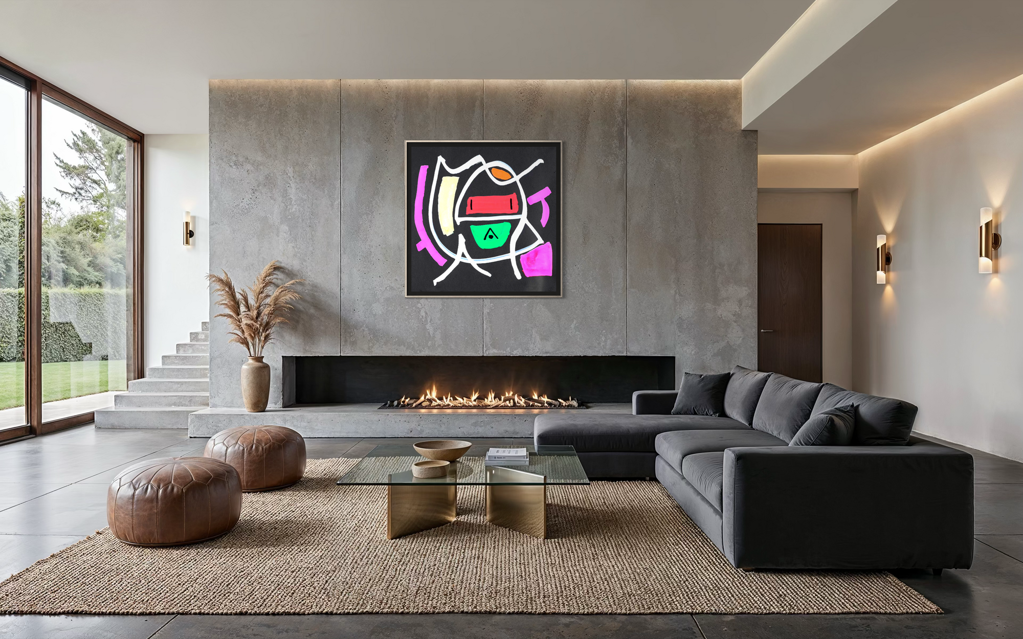 A modern living room with a large abstract colorful wall art print hanging above a fireplace. The room features a dark gray sectional sofa, brown leather poufs, a glass-top coffee table on a woven rug, and a concrete fireplace wall.