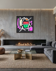 A modern living room with a large abstract colorful wall art print hanging above a fireplace. The room features a dark gray sectional sofa, brown leather poufs, a glass-top coffee table on a woven rug, and a concrete fireplace wall.