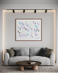 Living room area with off white couch and decorative brown and grey pillows.  Cocktail table set up in front of the sofa and a geometric abstract painting hangs above it 