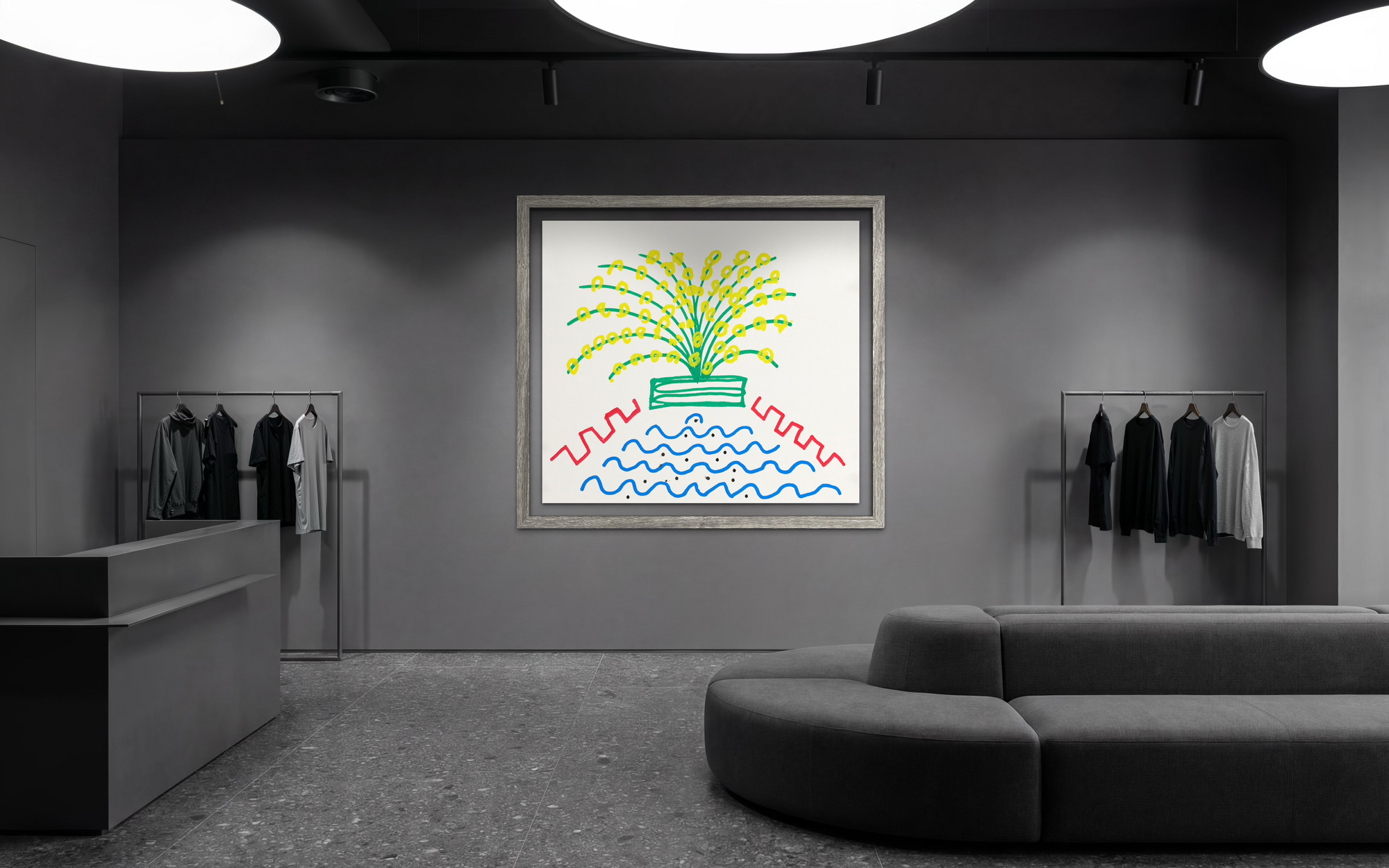 Dark grey sales floor setting with rounded couch seating, a sales desk, grey/black/white clothing hanging on racks on each side of a bright, colorful abstract piece of artwork