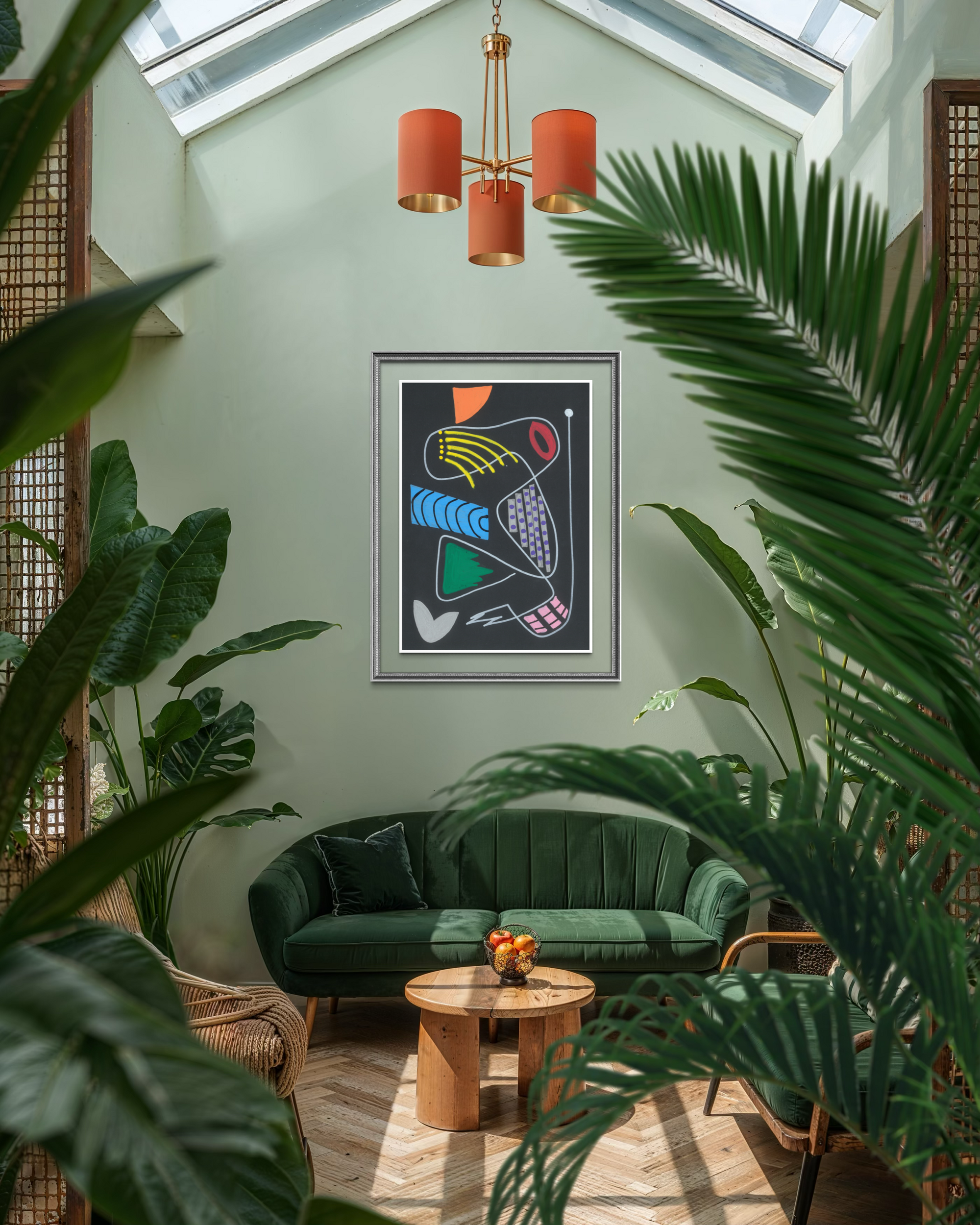 A framed abstract art print hangs on a sage green wall in a styled living room with a green velvet sofa, wooden coffee table, and large tropical plants in the foreground.