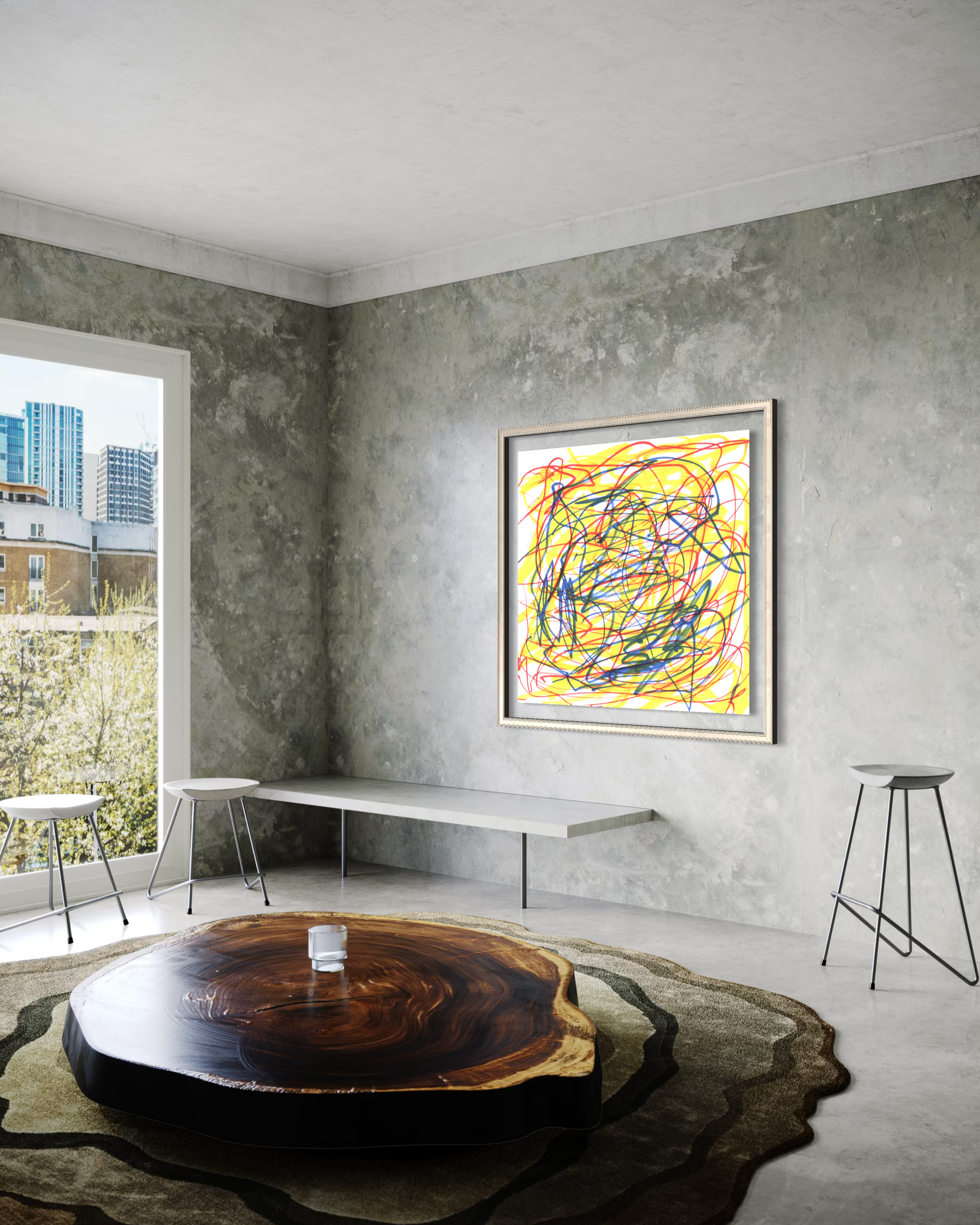A framed abstract art print with colorful scribbled lines on a yellow background, displayed on a textured gray wall in a modern minimalist room with a wooden table and concrete floors.