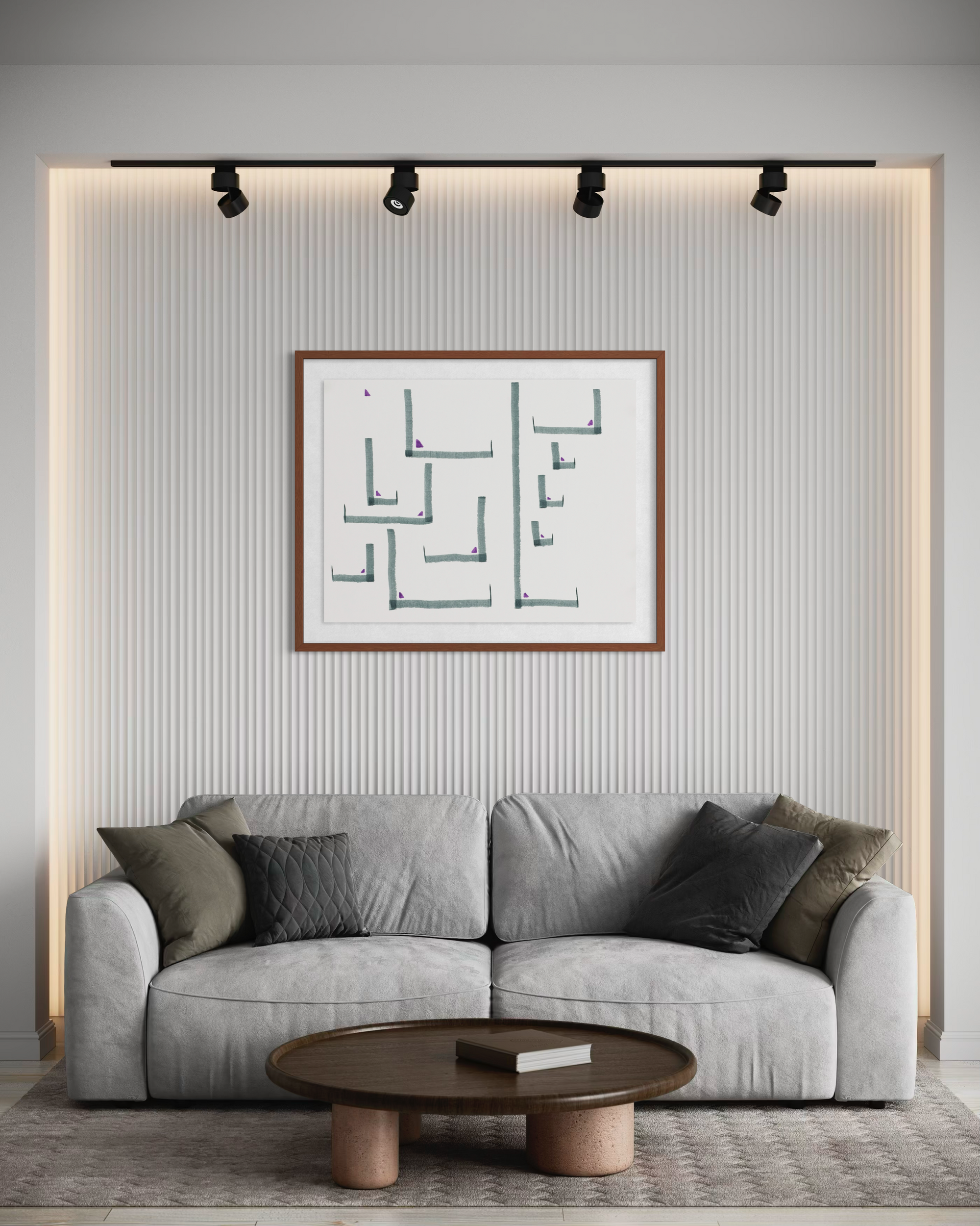 A modern living room setup featuring a light gray fabric sofa with dark accent pillows, a round dark wood coffee table, and a framed abstract geometric art print on a ribbed wall under track lighting.