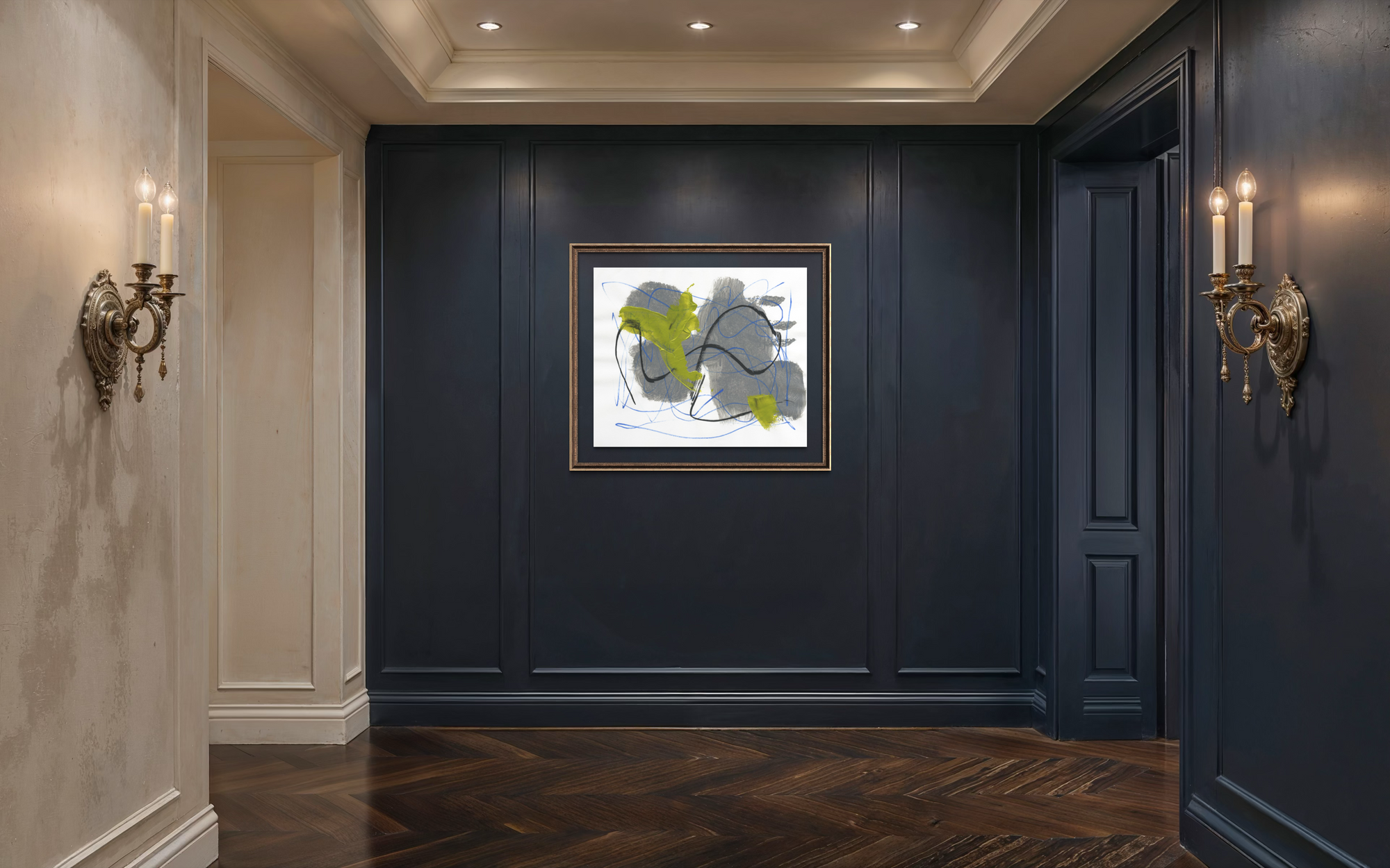 A framed abstract wall art print hangs on a dark navy paneled hallway wall, flanked by gold wall sconces and a wood herringbone floor.